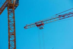 grattacielo costruzione gru con un' lungo giallo boom contro il blu cielo. foto