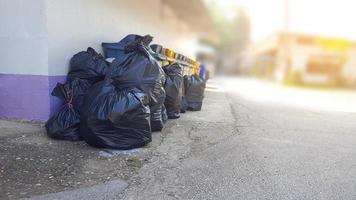 nero plastica spazzatura borse su il terra in attesa per riciclare foto