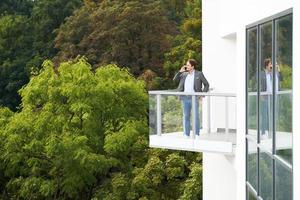 uomo d'affari in piedi su balcone contro natura foto