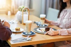 giovane coppia godendo caffè e torta nel bar foto