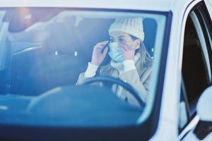 contento donna guida auto nel nevoso inverno indossare maschera foto