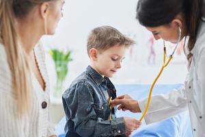 poco ragazzo avendo medico visita medica di pediatra foto