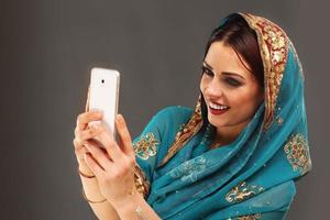 Arabo donna utilizzando smartphone foto