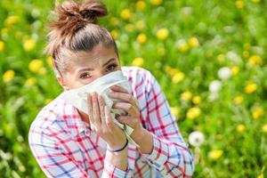 giovane donna avendo allergico sintomi con fazzoletto di carta foto