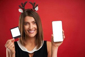 donna nel Natale umore confrontando immediato immagini per smartphone telecamera al di sopra di rosso foto