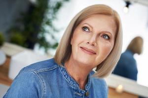 anziano donna in posa nel il bagno foto