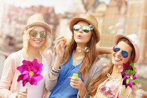 gruppo di amici soffiaggio sapone bolle foto