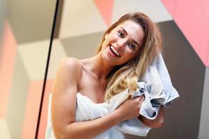 bellissimo bionda caucasico donna in posa nel bagno con bagnato capelli foto