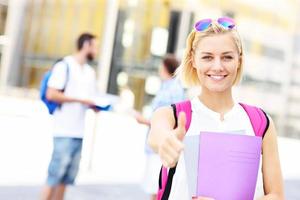 bella alunno mostrando ok cartello nel il città universitaria foto