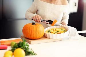 adulto donna nel il cucina preparazione zucca piatti per Halloween foto