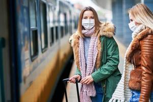 Due donne a treno stazione indossare maschere dovuto per covid-19 restrizioni foto