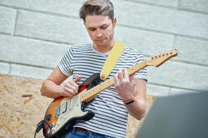 bello uomo giocando chitarra nel studio foto