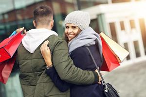 ritratto di contento coppia con shopping borse dopo shopping nel città foto