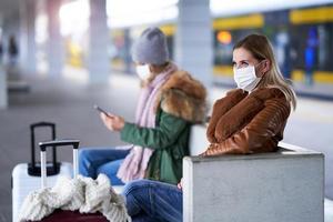 Due donne a treno stazione indossare maschere dovuto per covid-19 restrizioni foto