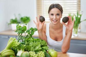 salutare adulto donna con verde cibo nel il cucina foto