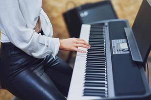 caucasico donna giocando su tastiera con gruppo musicale foto