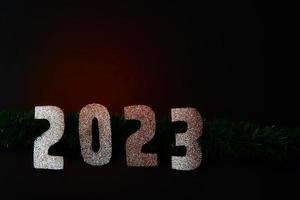 contento nuovo anno 2023. d'oro numeri su un' nero sfondo con luccichio foto
