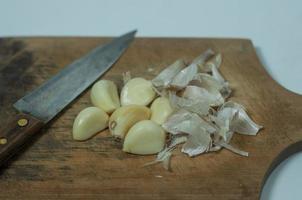 pelato aglio su di legno taglio tavola. naturale foto concetto