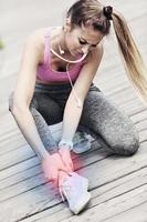 femmina atleta corridore toccante piede nel dolore all'aperto foto