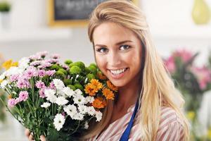 femmina fioraio Lavorando nel fiore negozio foto