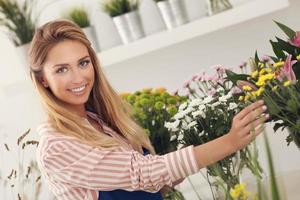 femmina fioraio Lavorando nel fiore negozio foto