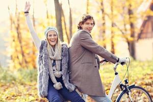 contento coppia su Bici nel foresta durante autunno tempo foto