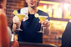 bello barista servendo cocktail nel un' pub foto