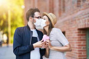 adulto romantico coppia indossare maschere su il camminare nel il città foto