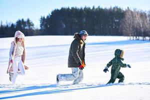 simpatico contento famiglia avendo divertimento su inverno neve foto