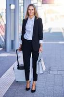 elegante donna a piedi con Borsa e valigia nel il ferrovia stazione foto