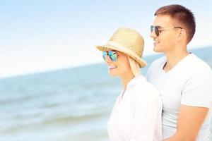 romantico coppia in piedi a il spiaggia foto
