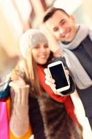 coppia mostrando smartphone mentre shopping foto