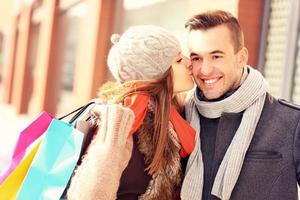 contento donna baci un' uomo mentre shopping foto