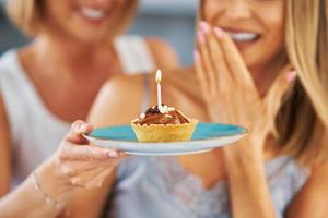 simpatico Due adulto ragazze nel il Casa con compleanno torta foto