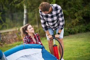 giovane simpatico coppia avendo divertimento su campeggio ambientazione su tenda foto
