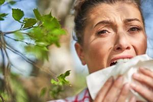 giovane donna avendo allergico sintomi con fazzoletto di carta foto