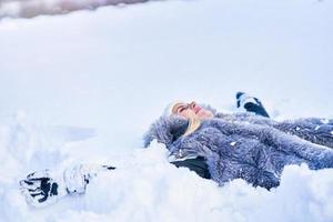 giovane simpatico donna dire bugie su il neve foto