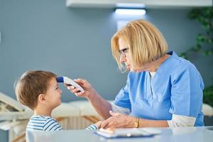 pediatra medico l'esame poco bambini nel clinica temperatura dai un'occhiata foto