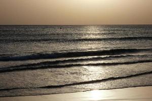 sole ambientazione al di sopra di il mare, tramonto nel autunno su il spiaggia di zahara de los intona, Cadice, andalusia, Spagna foto