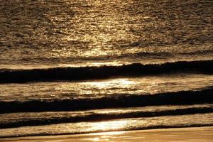 sole ambientazione al di sopra di il mare, tramonto nel autunno su il spiaggia di zahara de los intona, Cadice, andalusia, Spagna foto