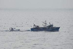 pescatori ritorno a partire dal pesca a alba dopo la spesa il totale notte a mare. foto
