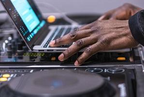 dj giochi vivere impostato e miscelazione musica su il computer portatile. disco scherzo mani su un' il computer portatile a club. foto