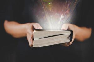 giovane donna persona mano Tenere santo Bibbia con studia a casa. adulto femmina cristiano lettura libro nel Chiesa. ragazza apprendimento religione spiritualità con pregare per Dio. concetto di alunno formazione scolastica fede. foto