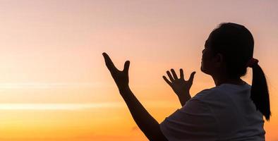 silhouette di donna mano preghiere spiritualità e religione, femmina culto per Dio. cristianesimo religione concetto. religioso persone siamo umile per Dio. cristiani avere speranza fede e fede nel Dio. foto