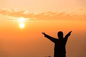 concetto cristiano persona culto o pregare per Dio. cristiano donna silhouette con amore, fede, devozione per Dio con Alba cielo sfondo. culto Dio per pace, vittoria, successo con speranza. religione foto