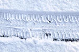 vicino su Visualizza pneumatico brani a il superficie di fresco caduto neve. foto