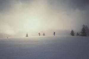 sciatori su nevoso collina paesaggio foto