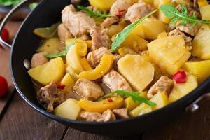 in umido patate con carne e verdure nel un' torrefazione lattina su un' di legno sfondo foto