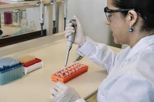 scienziato pipettaggio campioni a partire dal eppendorf tubi foto