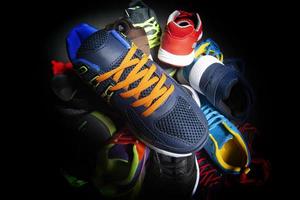 sport scarpe. vario scarpe da ginnastica su un' buio sfondo. foto